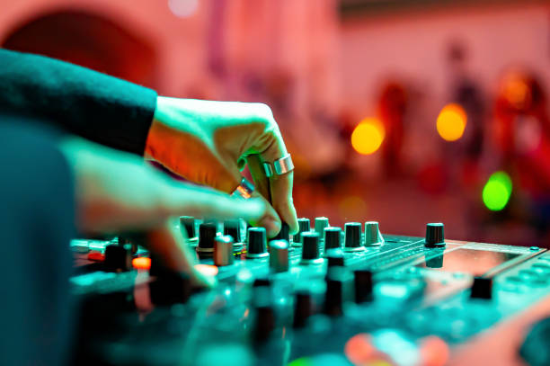 femme DJ Hands créant et régulant de la musique sur une console de mixage DJ en concert - Photo