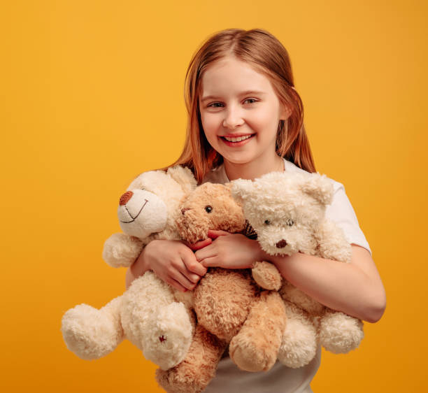 istock Girl with teddy bear isolated on yellow background 1508610242