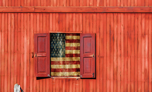 Wooden architecture with hanging US flag on window.