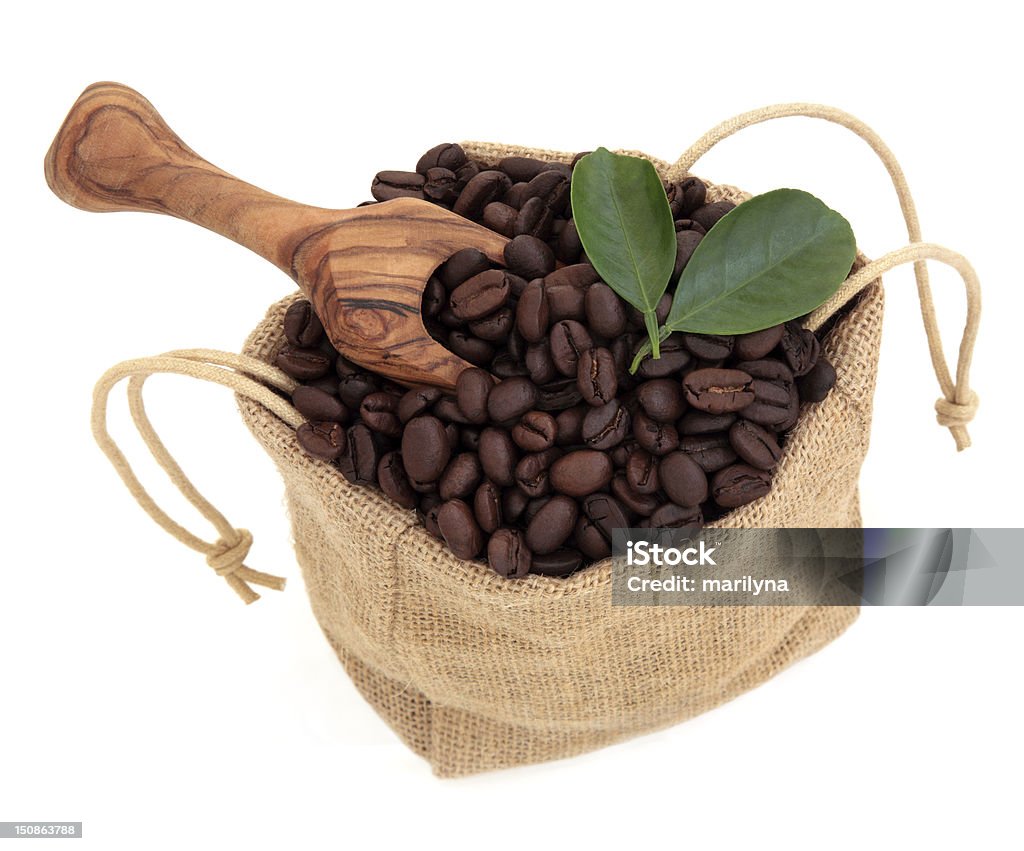 Coffee Beans Coffee beans in a hessian drawstring sack and loose with leaf sprigs and olive wood scoop over white background. Bag Stock Photo