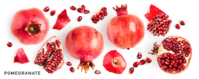 Pomegranate with seeds and half slice flying in the air isolated on white background.