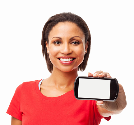 Portrait of beautiful young African American woman in a casual red t-shirt showing smart phone with blank screen. Horizontal shot. Isolated on white.