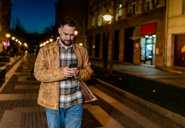 istock Young man walking and texting on his phone 1508715872