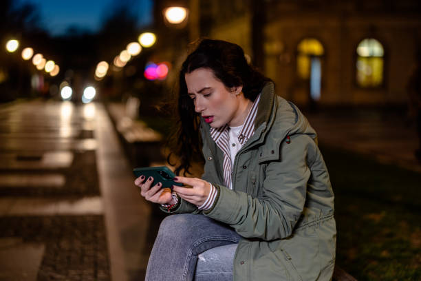 istock Young Woman Keeps Up with the Game on Her Phone While Taking a Break on a Bench 1508720805