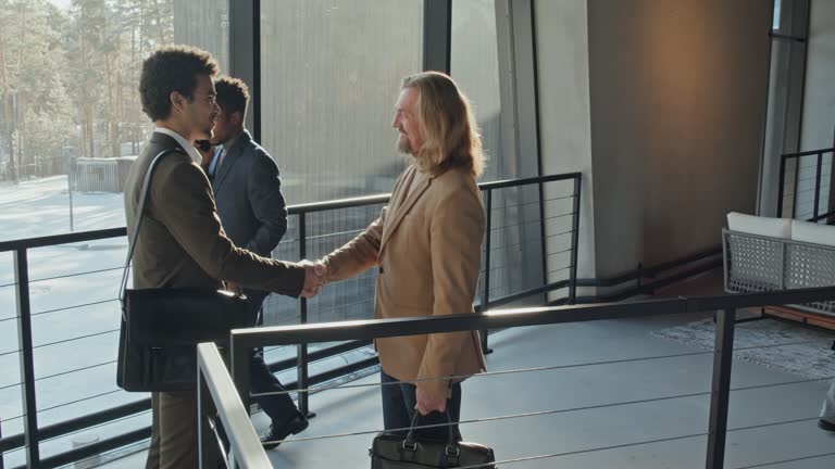 Caucasian Businessman Shaking Hands with Candidate in Lobby