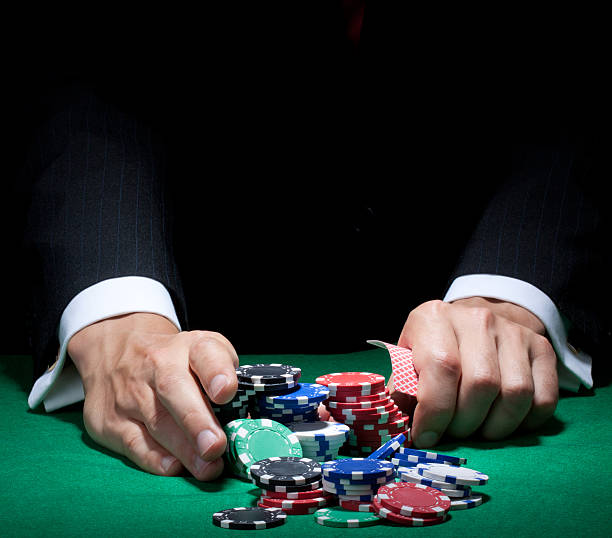 istock Man's hands pushing poker chips and holding cards on a table 150872645