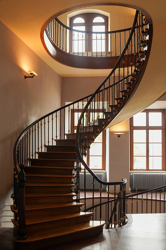 Winding spiral staircase with ornate wooden railings