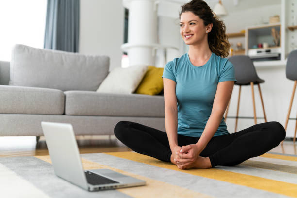 istock Cheerful smiling young female stretching her body while watching video tutorial on laptop during her free time 1508782359
