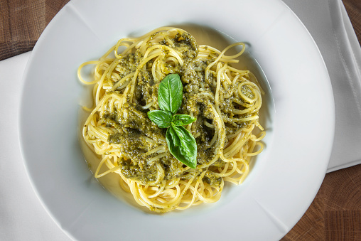 Pasta spaghetti with pesto sauce on a wooden table