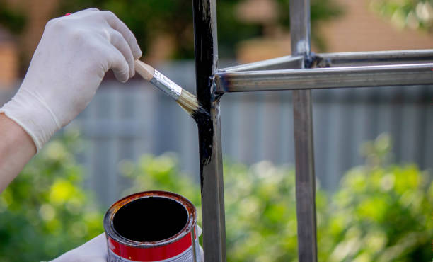 istock a man paints metal with black paint with a brush. 1508783501