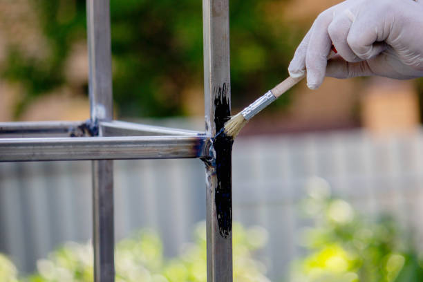 istock a man paints metal with black paint with a brush. 1508783506