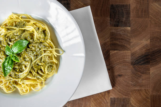 Pasta spaghetti with pesto sauce on a wooden table
