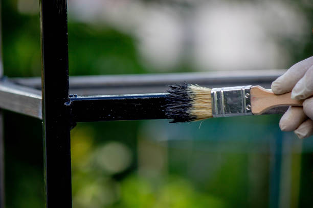 istock a man paints metal with black paint with a brush. 1508783520