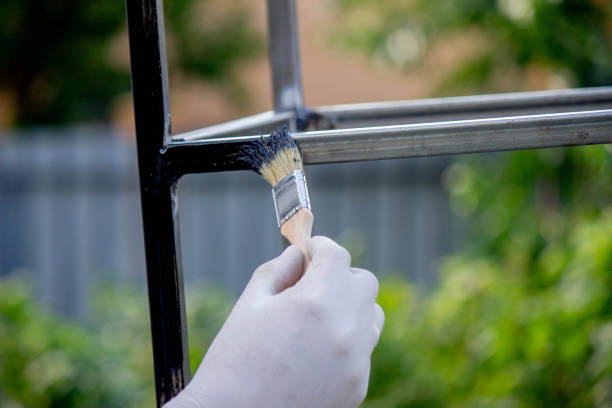 istock a man paints metal with black paint with a brush. 1508783521