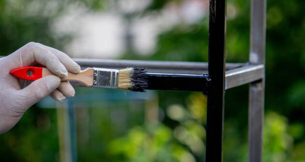istock a man paints metal with black paint with a brush. 1508783524