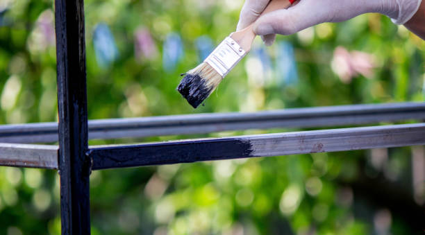 istock a man paints metal with black paint with a brush. 1508783525