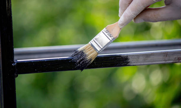 istock a man paints metal with black paint with a brush. 1508783527