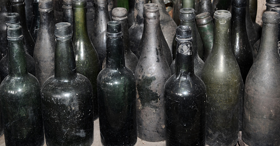 Lined with various old green glass bottles looking dirty and dusty.