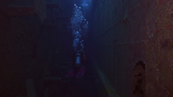 Scuba diver swim inside of ferry Salem Express shipwreck, Red sea, Safaga, Egypt