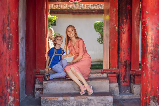 Mother and son tourists in Temple of Literature in Hanoi in Southeast Asia, Vietnam. Temple of Confucius in Vietnamese capital. Vietnam reopens after coronavirus quarantine COVID 19.