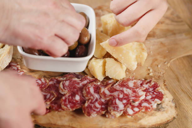 hands taking italian antipasti appetizers on table closeup