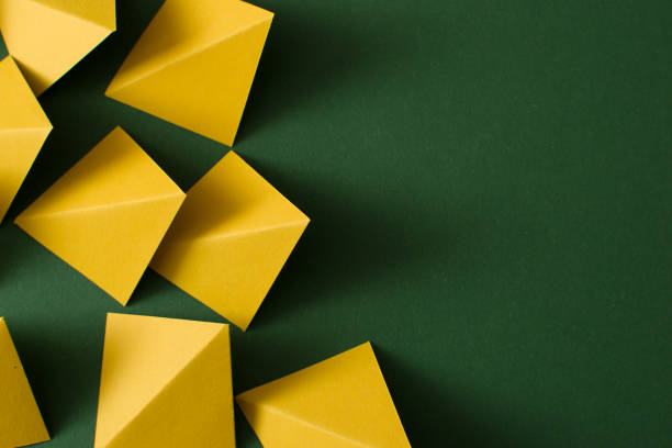 istock Yellow triangle shapes on green background, copy space, top view 1508909877