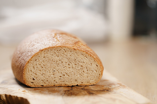 sliced rye wheat rustic bread on cutting board, shallow focus