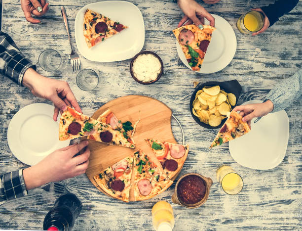people eating pizza with chips and sauces
