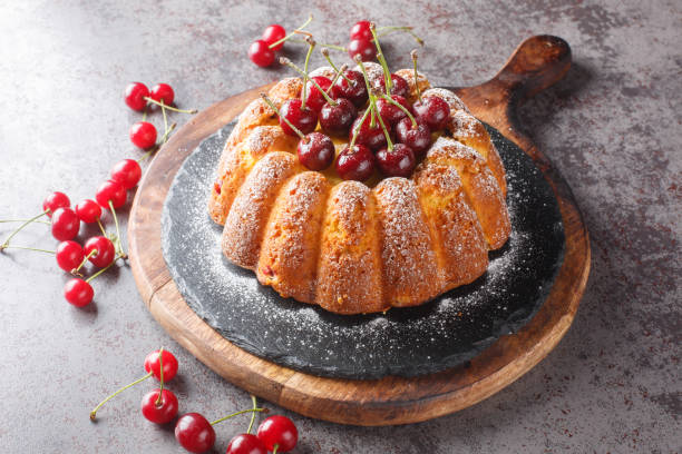 istock Rustic style cherry cake decorated with fresh berries and powdered sugar close-up on a wooden board. Horizontal 1508940323
