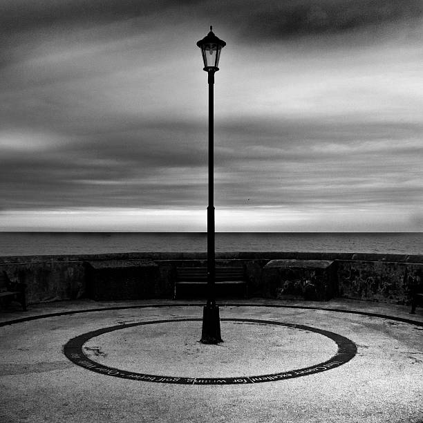 черный и белый пейзаж cromer лампа столб с видом на побережье. - black and white landscape square long exposure стоковые фото и изображения