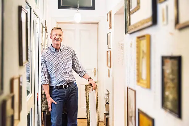 Art collector or antique Shop Owner in his apartment corridor. 