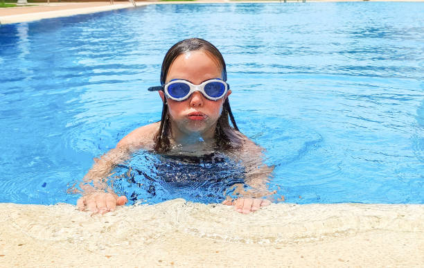 7 세의 백인 소녀가 야외 수영장에서 수영을하고 물속에서 넙치를합니다. 여름 화창한 날. - female 8 9 years child excitement 뉴스 사진 이미지