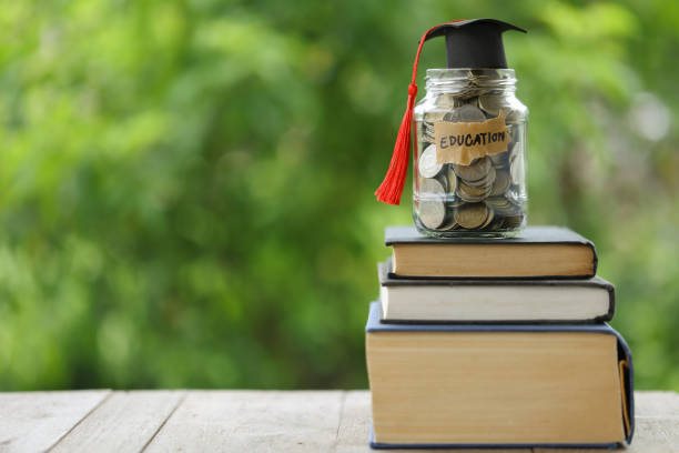 istock Knowledge and Success: Graduation Cap on Books Against a Beautiful Nature Background. Achievement Unlocked: Graduation Cap and Books Symbolize Education Savings and Academic Growth. 1508977034