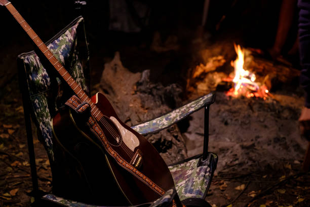 istock Acoustic guitar in camping chair with fire flame on background. summer camping. 1508981116