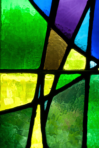 A close-up shot of a stained glass window with green and blue design. The pattern seems modern. The shot is taken from İstanbul, Turkey.