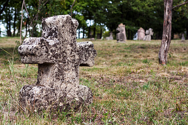 выветрившийся gravestone в старое кладбище - old cross shape stone weathered стоковые фото и изображения