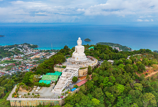 Beautiful Phuket white Big Buddha statue on blue sky background. Aerial view of Big Buddha viewpoint at sunrise in Phuket province, Thailand.