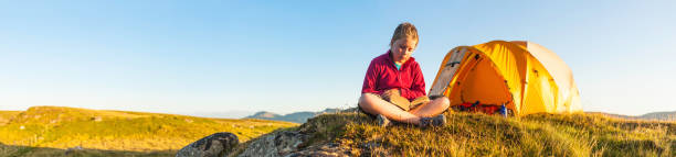 istock Child reading idyllic summer camp sunset panorama 150899785