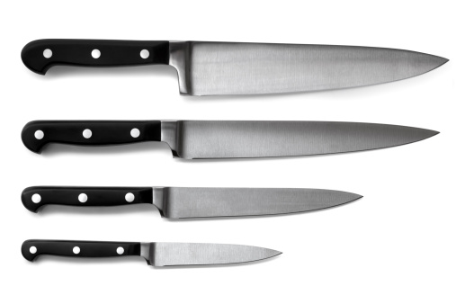 Set of steel kitchen knives, isolated on white with soft shadows. Includes carving, paring, and utility knives.