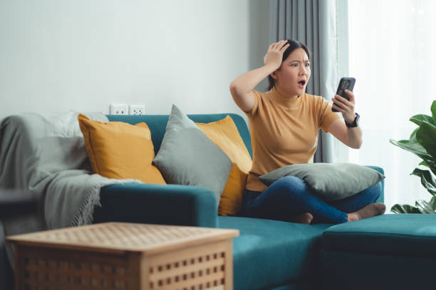 istock Asian woman sitting at home looking at smartphone screen and having problem. 1509016454
