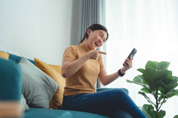 istock Asian woman sitting at home looking at smartphone screen and having problem. 1509017034