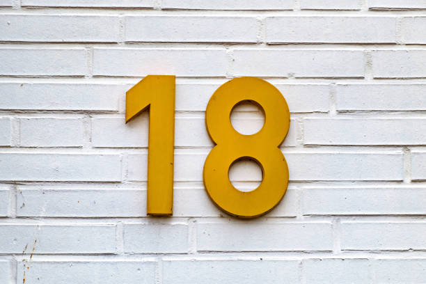 istock White brick wall with yellow sign on it that says'18 ' in Germany. 1509038032