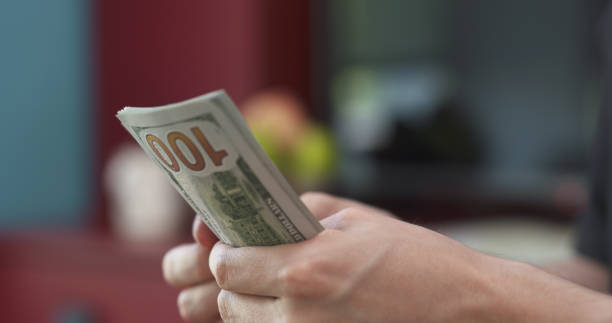 istock side shot of man counting three thousand dollars 1509044370