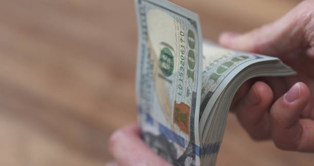 istock closeup man hands flipping dollars 1509044989