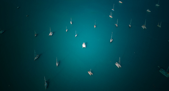 High angle view of many boats in the blue sea. and focus on the boat in the middle of andaman ocean near phuket island.