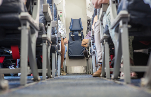Normal class passenger jet airliner corridor. Tail stewardess seat