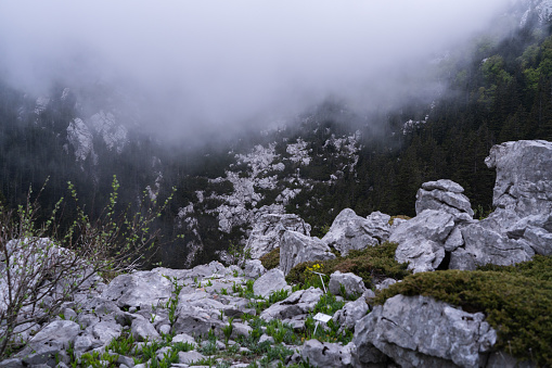 Scenic aerial view of karst mountains in clouds at sunrise