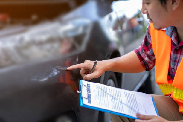 istock Insurance man inspecting a broken car after an accident as evidence for making an insurance claim 1509134308