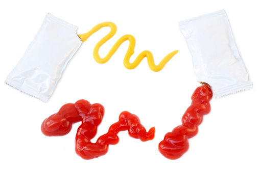 Ketchup and mustard packets isolated on a white background.