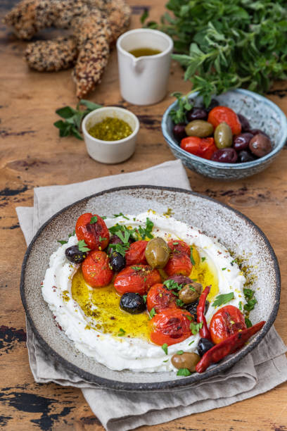 istock Popular middle eastern appetizer labneh .Cream cheese dip with olive oil, Cherry tomatoes,cucumber, herbs and olives 1509195355